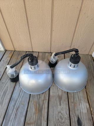 Brand new retractable heat lamps for food warming, shown unused with coiled cords and protective coverings, ideal for catering.