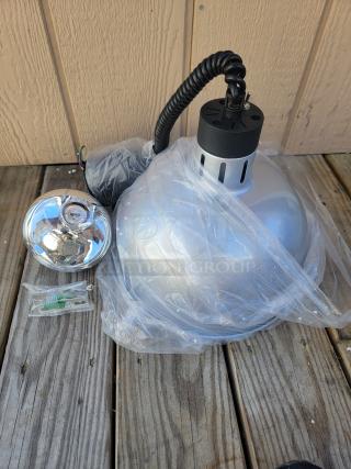 Brand new food warmer retractable heat lamp, silver, with coiled cord, wrapped in plastic, ideal for commercial use.