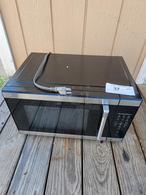 Hamilton Beach 1.1 cu. ft. countertop microwave, black and stainless steel, digital keypad, lightly used, auction tag visible.