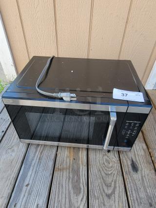 Hamilton Beach 1.1 cu. ft. countertop microwave, black and stainless steel, digital keypad, lightly used, auction tag visible.