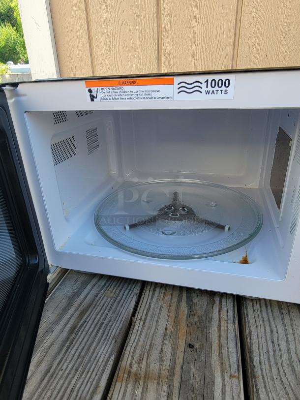 Hamilton Beach 1.1 cu. ft. countertop microwave, 1000 watts, interior view, includes glass turntable, slight interior stain.