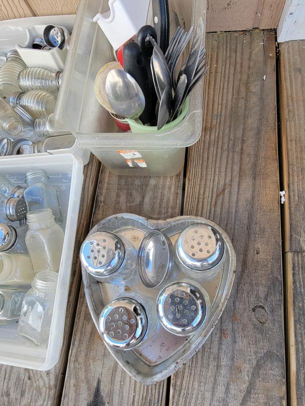 Assorted kitchenware includes spice jars, utensils, and a heart-shaped spice holder. Items appear gently used.