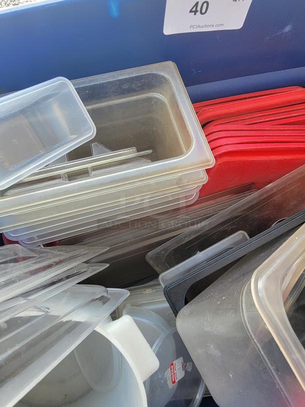 Assorted commercial kitchen storage containers and lids in durable plastic and metal, ideal for culinary use; includes various sizes.