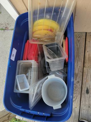 Assorted commercial kitchen storage containers and lids in plastic and metal, varied sizes, suitable for restaurants or catering.