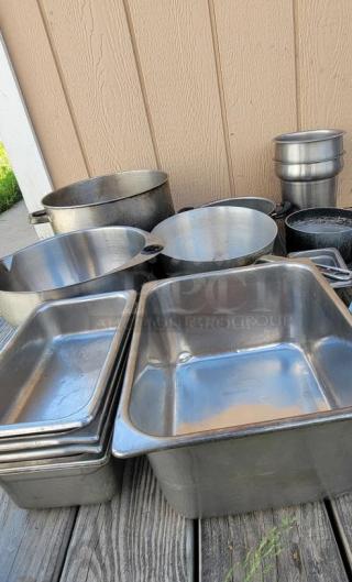 Assorted stainless steel and aluminum cookware and utensils, ideal for commercial kitchens. Includes pots, pans, and trays.