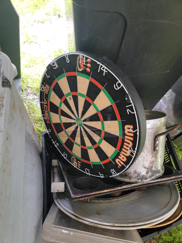 Lot of assorted kitchen items with gas fittings, bakeware, and a Rubbermaid trash can. Includes muffin pans, metal trays, and a dartboard. Appears used.