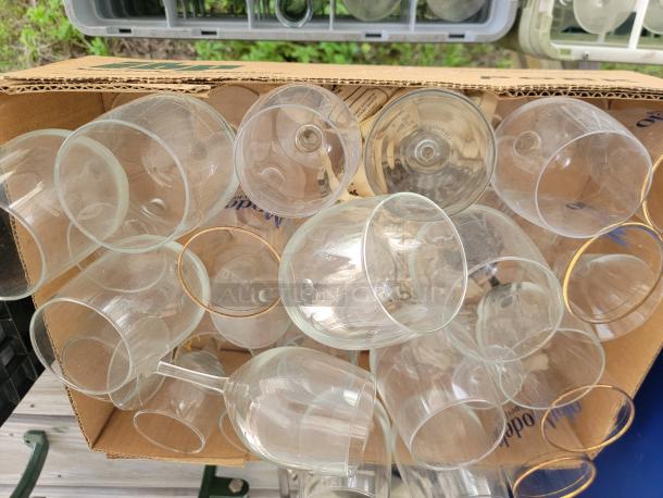 Assorted glassware lot in a box, including various shapes and sizes. Ideal for collections, crafts, or kitchen use.