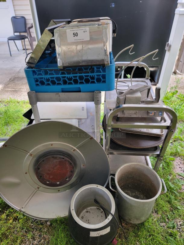 Assorted commercial kitchen lot with toasters, bakeware, pots, trays, vegetable slicer, and banana holders. Visible label indicates quantity 50.