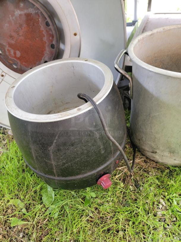 Assorted commercial kitchen lot featuring cooking pots and an electric appliance on grass.