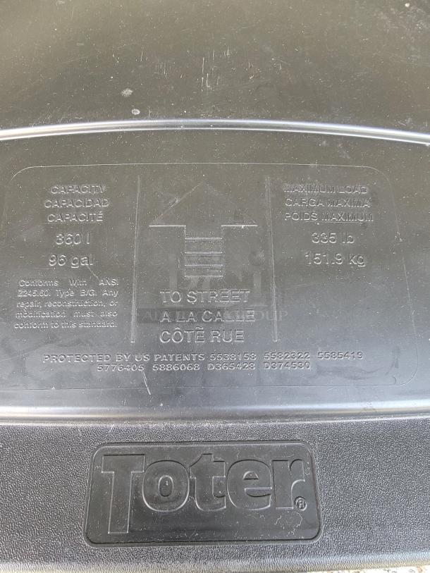 Rubbermaid 96-gallon Toter bin lid detail, showing capacity and maximum load markings. Ideal for garage or workshop use.