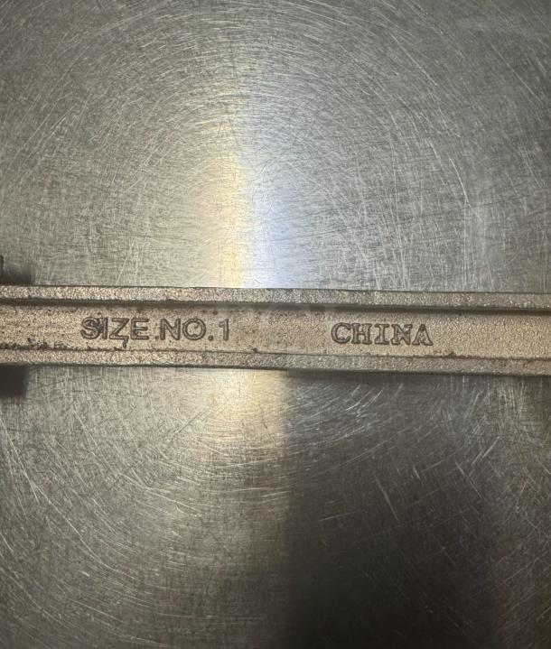 Heavy-duty commercial can opener, marked "Size No. 1, China," features robust metal construction for large cans. Ideal for restaurants.