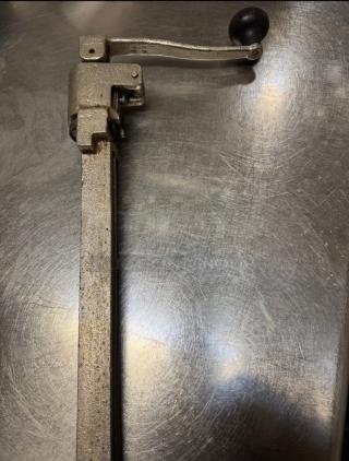 Heavy-duty commercial can opener with robust metal construction and manual handle, designed for large cans. Ideal for busy kitchens.