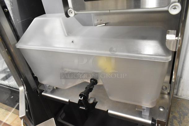 Stainless steel JBT 2ND-GEN-MFJ-HE citrus juicer, floor style, on casters. Features durable build, used for commercial purposes.