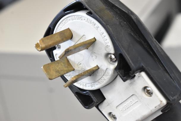 Close-up of a Hubbell plug for a Turbochef HhC2020 rapid cook conveyor oven, showing prongs and plug details.