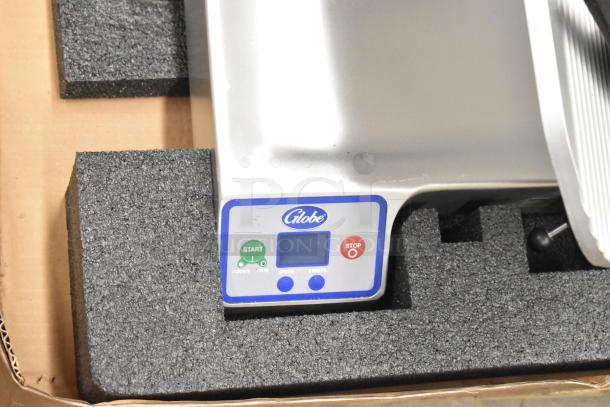 Globe SG13A-24 commercial meat slicer with 13" blade, blade sharpener, control panel visible. Scratch and dent condition.
