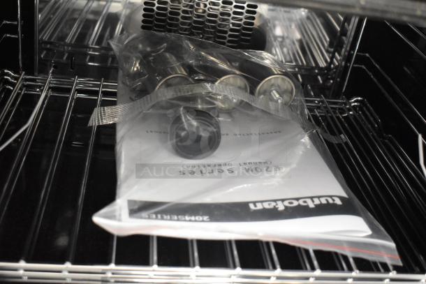 Brand new Moffat E22M3 Turbofan half-size convection oven interior, showing shelves, manual, and components in packaging.