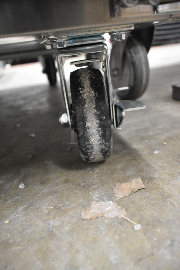 Close-up of caster wheel on a 2025 Mainstreet 829PT60 Commercial Sandwich Salad Prep Table. Visible wear; sturdy design.