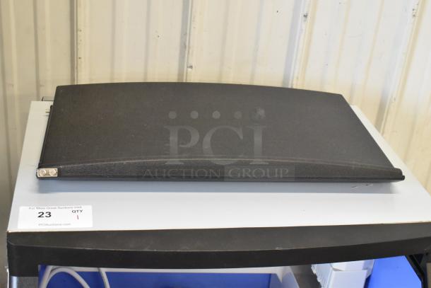 Alt text: Black ice machine lid on a metal shelf, labeled "23 QTY 1" and "PCIAuctions.com."