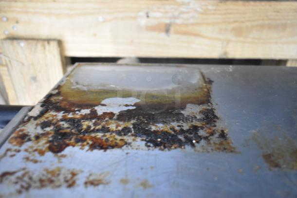 BRAND NEW SCRATCH AND DENT CPG Commercial Gas Griddle with rusty, scratched cooking surface. Thermostatic controls visible.