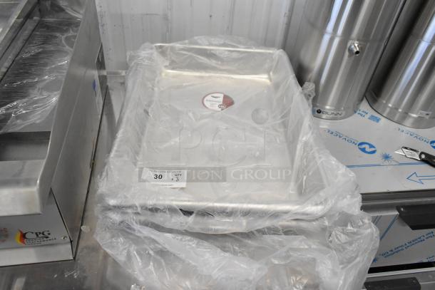 3 new Vollrath aluminum sheet pans, model 9001, in plastic wrap. Slight scratch and dent. Auction lot tag visible.
