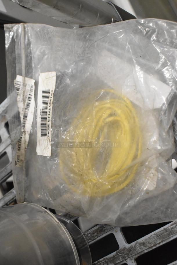 Bag containing a yellow probe kit labeled "LAE Control" on a metal shelf, part of a 6-item auction lot.