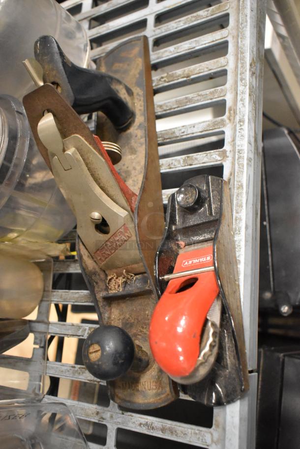 Vintage Stanley wood planes with red and black handles, showing mild wear.