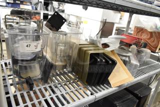 Lot of clear poly bins and lids with metal shelving. Includes various kitchen items. Condition appears used. Auction tag visible.