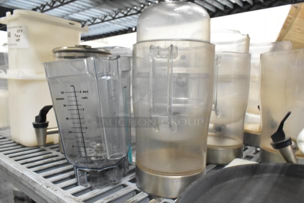 Alt text: Lot of clear poly pitchers, bins, and dispenser on a metal shelf, showing usage marks and measuring labels.