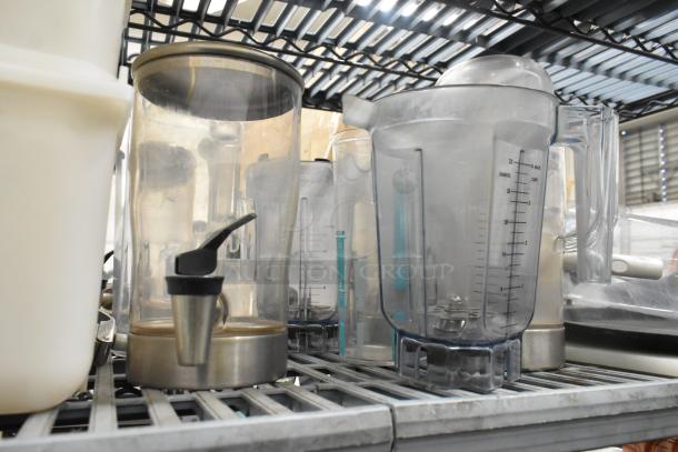 Lot of clear poly pitchers, bins, and dispensers on a metal shelf. Items display measurement markings, appear gently used.