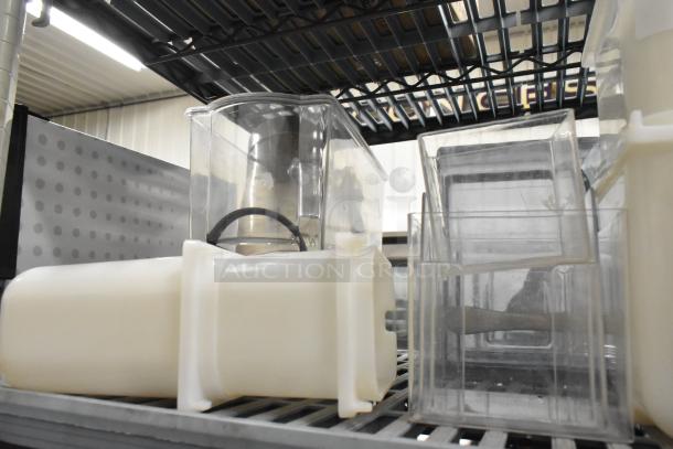 Lot of clear poly pitchers, bins, and dispenser on metal shelf; used condition, suitable for kitchen storage or serving.