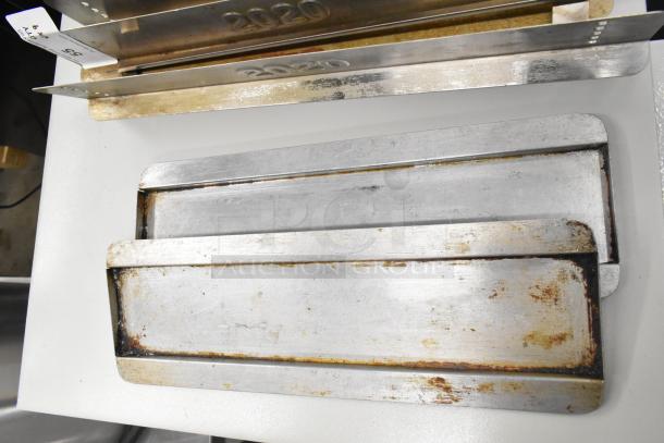 Nine metal pieces for Turbochef Rapid Cook Conveyor Ovens, showing wear, marked "2020," and includes bidding tags.