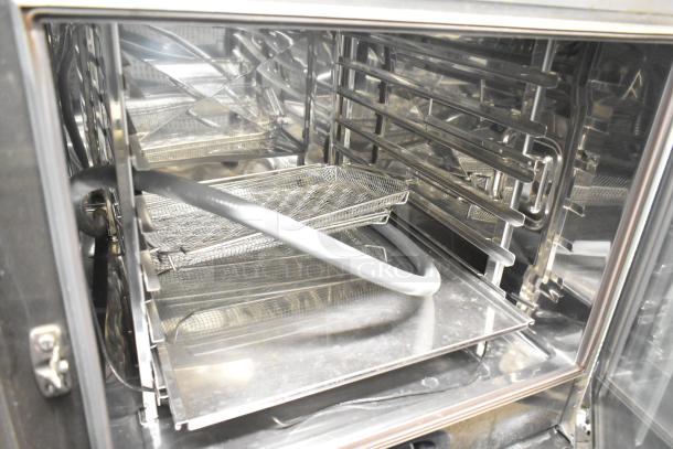 2019 Rational SCCWE62 convection oven interior with stainless steel racks, on equipment stand with commercial casters. 480V, 3 phase.