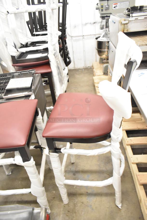 10 new Lancaster bar stools with black window pane back and red cushioned seats, partially wrapped for protection.