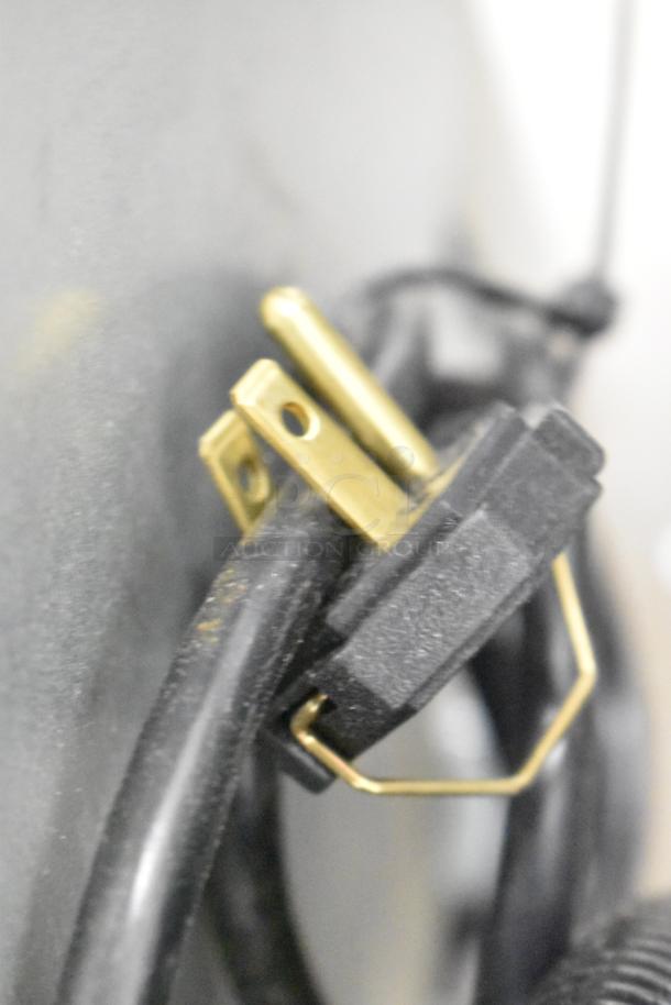 Close-up of a power plug attached to a Manitowoc UDP0065A-161 ice machine, highlighting connectivity features.