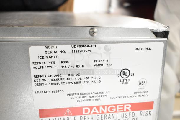 BRAND NEW Manitowoc UDP0065A-161 undercounter ice machine, 115V, 62 lb. capacity. Features model, serial, and specification labels.