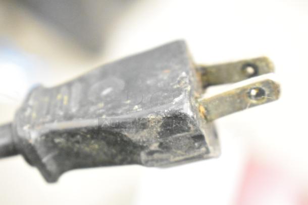 Close-up of a worn power plug from the Robot Coupe R2N food processor base. 120 volts, 1 phase. Marks of wear visible.