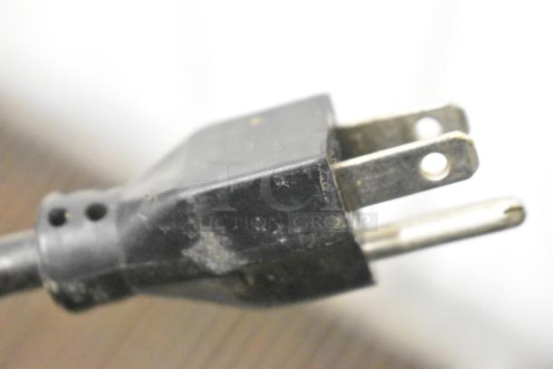 Robot Coupe R2B food processor base plug, 120 Volts, 1 Phase, metal prongs, black plastic casing, some wear visible.