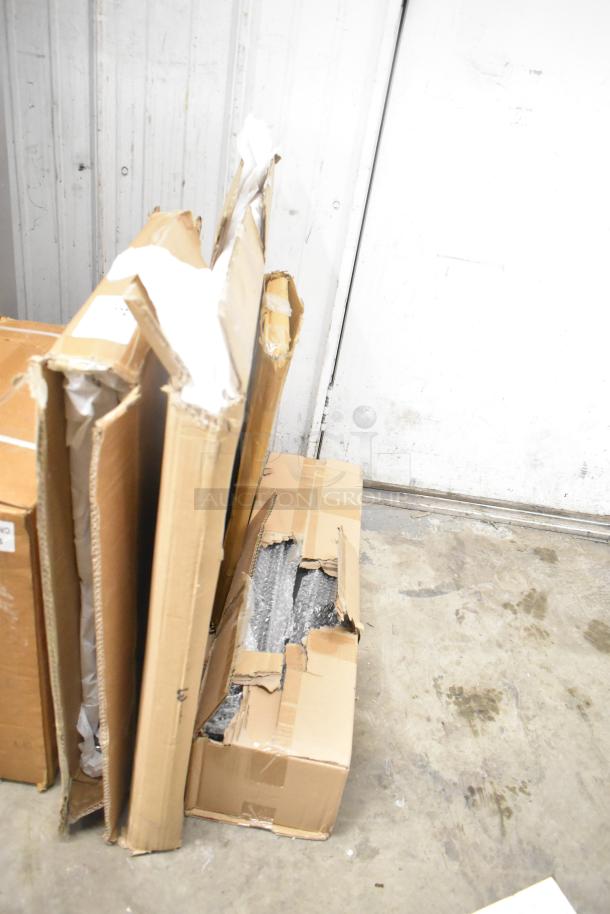 Four boxed items, including Bon Chef 52109 EX Fit Tile Pattern Tabletop, metal oven racks, and legs, visible damage on boxes.