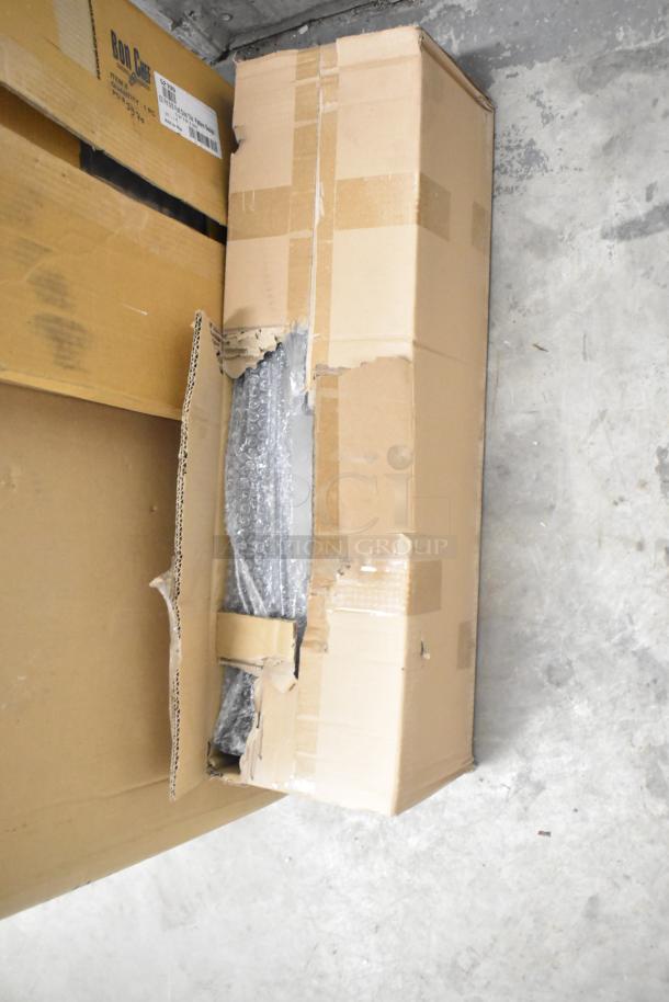 Four boxes of new scratch and dent items including Bon Chef 52109 tabletop, boxes of legs, and metal oven racks.