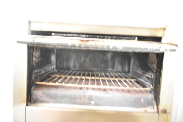 Garland stainless steel commercial gas-powered vertical upright broiler in used condition, with visible interior grill.