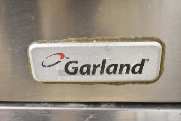 Garland stainless steel commercial gas-powered vertical upright broiler, featuring Garland logo, showing moderate wear.