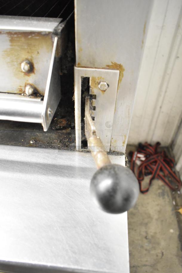 Garland stainless steel gas broiler lever, showing adjustable mechanism. Slight wear visible, highlighting durable construction.