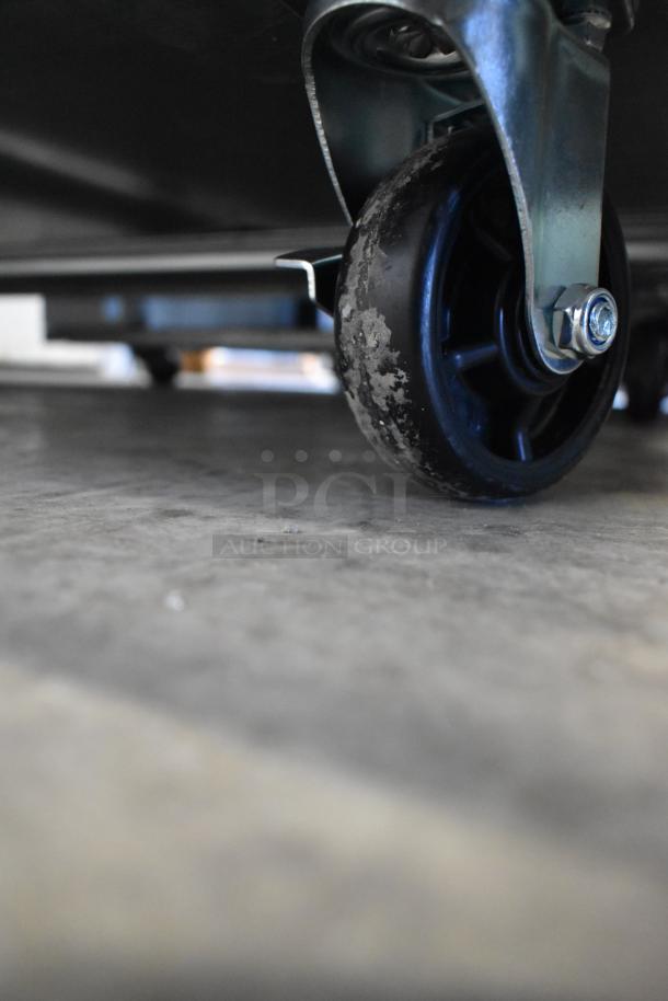 Close-up of a caster wheel from a BRAND NEW Avantco 178APT60MHC 60" 2 Door Refrigerated Sandwich Prep Table, showing condition.