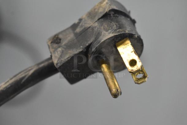 Close-up of a dusty electrical plug, likely from the Beverage Air UCR48A cooler, showing wear but intact.