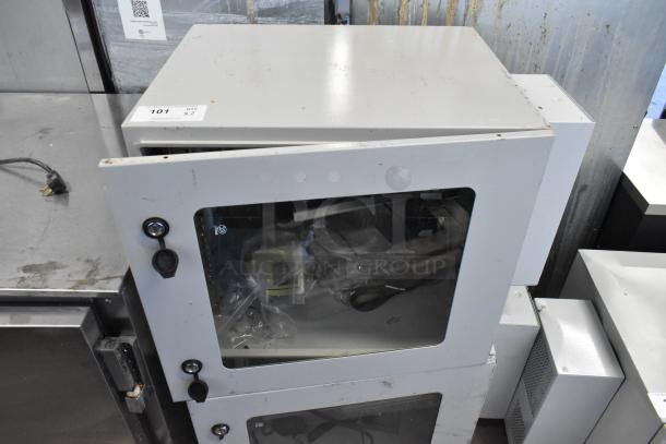 2 BlackShields DC0300 white metal cabinets, air-conditioned, visible wear, glass doors, label indicates "101 X2".