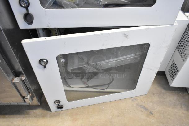 Two BlackShields DC0300 white metal air-conditioned technology cabinets, visible wear, clear front panel, secure locking.