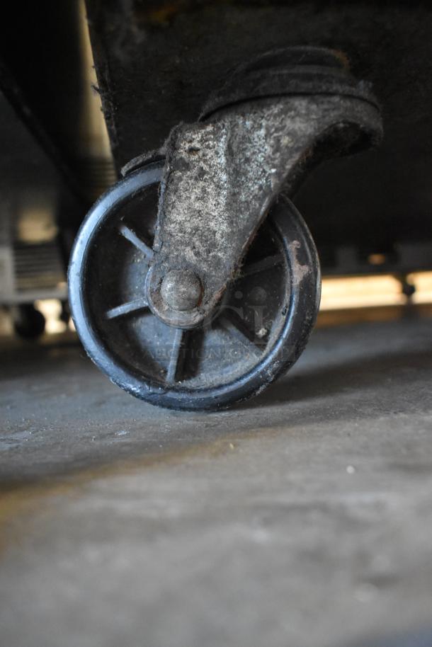 Turbo Air M3F24-1 freezer caster wheel showing signs of use. Includes poly coated racks, runs on 115 volts, 1 phase.