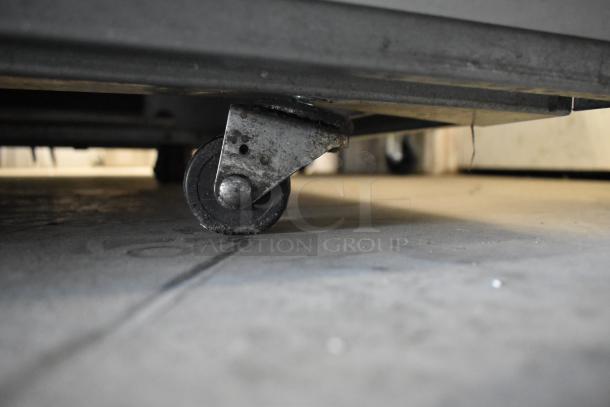 Master-Bilt BLG-80HD freezer's commercial caster, showing durable wheel and metal frame, attached to base.