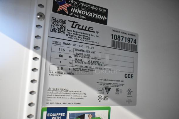 Label on 2024 True GDM-35-HC cooler showing model info, voltage, refrigerant type, and compressor details.