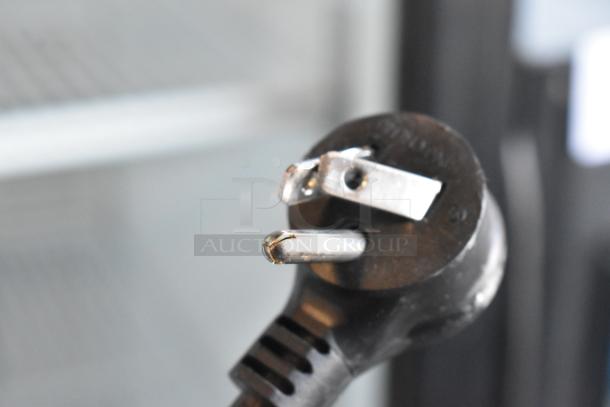 Close-up of a power plug for the Habco SE12HC commercial cooler, showing a three-prong configuration. Background shows interior shelves.